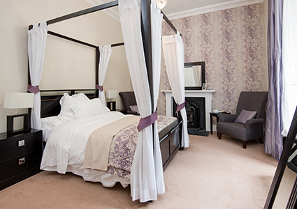 A bedroom with a 4 poster bed in Stuckgowan House by Loch Lomond
