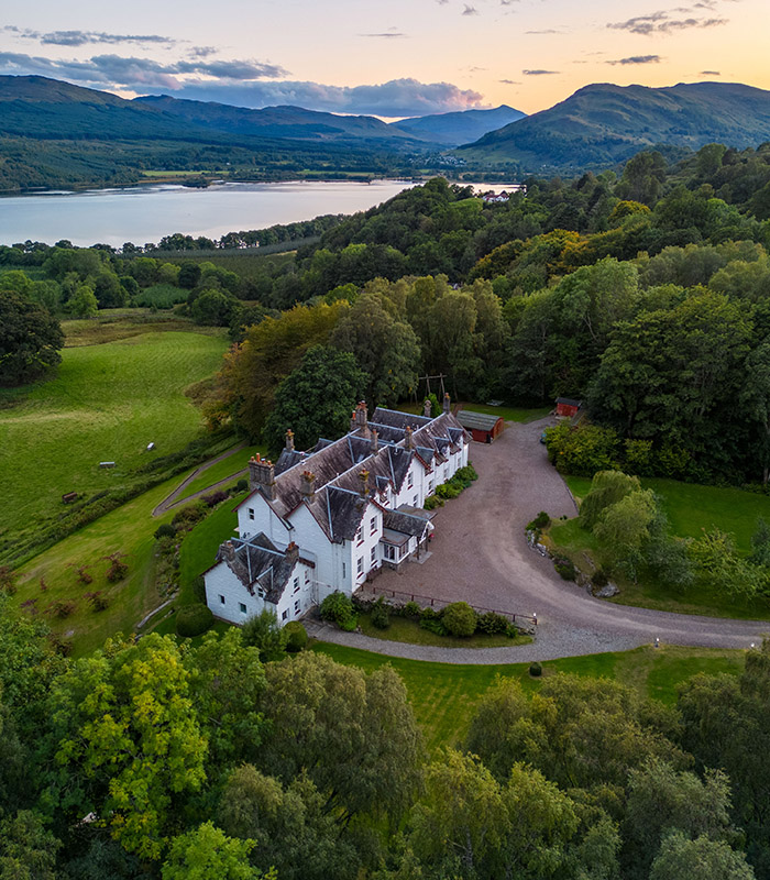 An aerial view of Stucktaymore house with Loch Tay and the rolling hills in the background