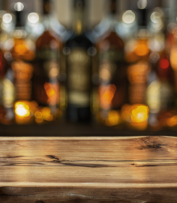 Blurred whisky bottles behind a bar
