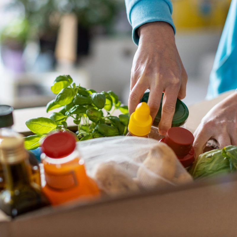 Woman unpacking box of groceries