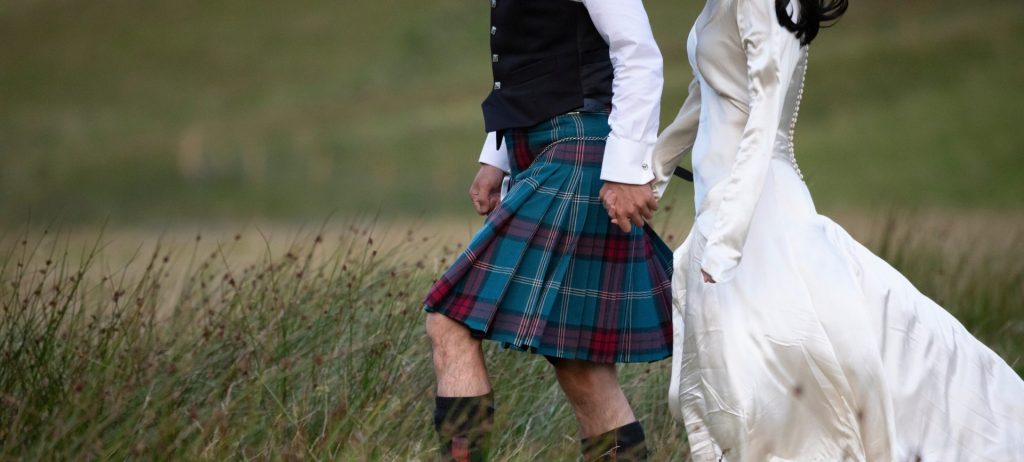 A Scottish bride and groom walking the Scottish hills.