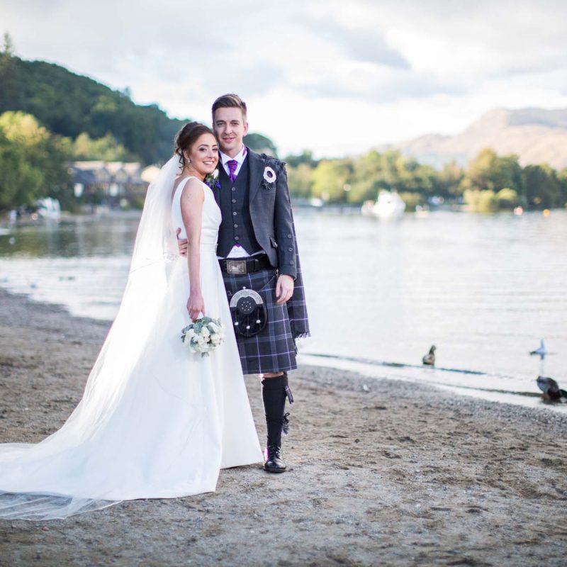 A bride and groom on the shores of Loch Lomond at their wedding at Stuckgowan next to Loch Lomond