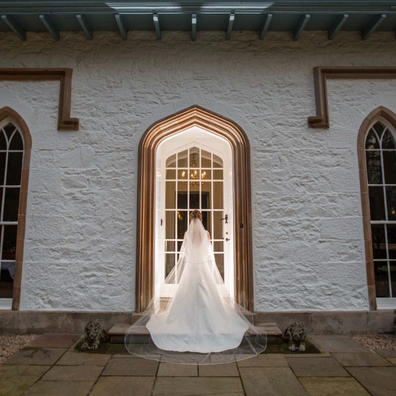 A bride stood in the elegant arched doorway of Stuckgowan by Loch Lomond