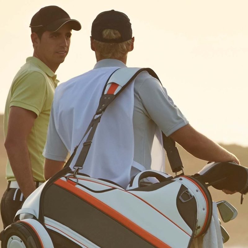 Two golfers enjoying a sunset game.