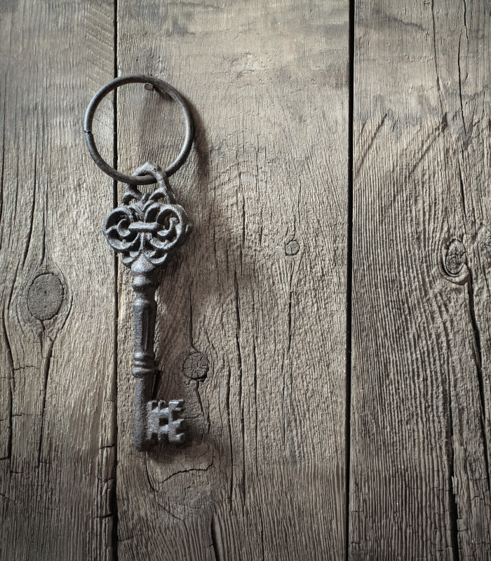 An old iron key hanging from a door