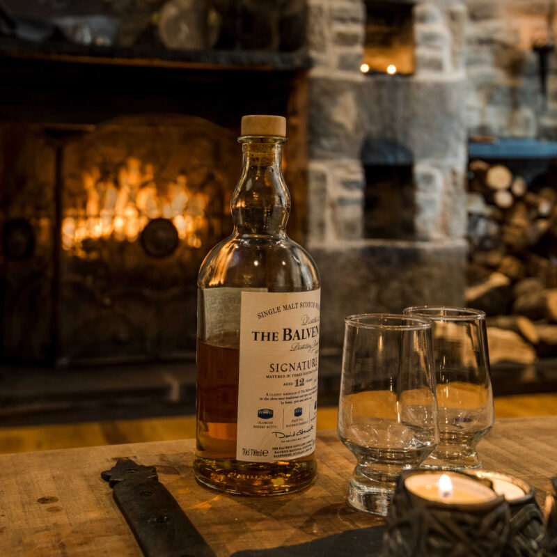 Bottle of whisky in front of the warm fire